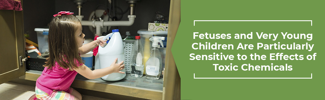 Young Child Picking up a Bottle of Bleach From Under the Sink