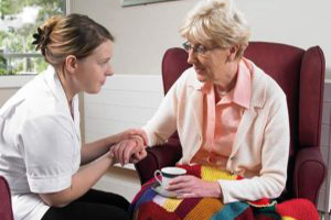 Nurse Helping Elder in Nursing Home